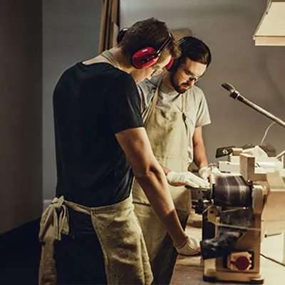 Due artigiani con cuffie e paraorecchie