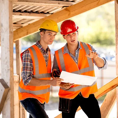 Due operai settore edilizia con giubbino ed elmetto