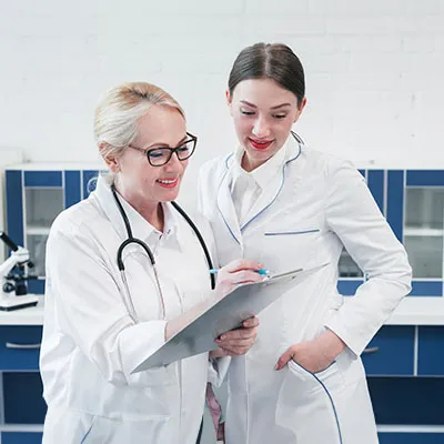 Due donne che lavorano nel settore sanità con camice bianco