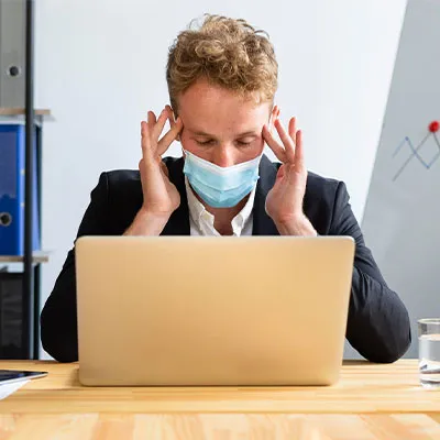 Lavoratore al computer con mascherina pandemia