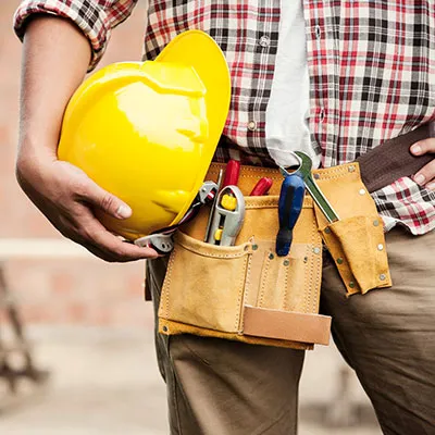 Lavoratore edilizia con casco giallo in mano
