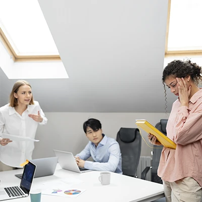 Tre persone che parlano attorno a una scrivania d'ufficio