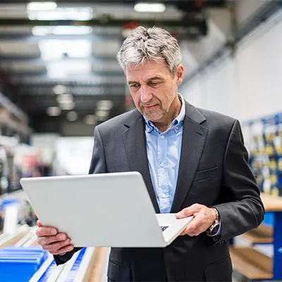 Uomo in piedi con laptop in mano