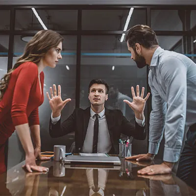 Uomo che placa la discussione tra due colleghi, esempio di rischio aggressione