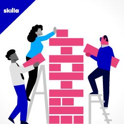 Tre persone che costruiscono un muro di mattoni