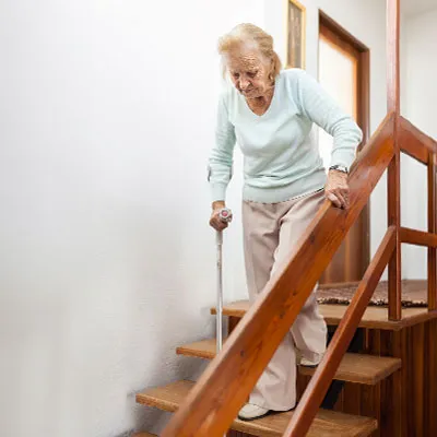 Donna anziana che scende le scale
