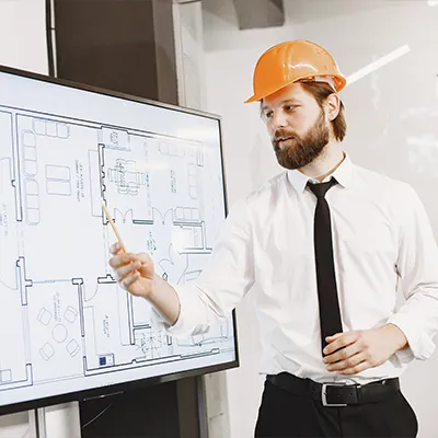 Immagine copertina corso online. Architetto Coordinatore BIM svolge una presentazione mostrando la planimetria di un edificio
