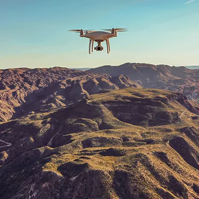 Immagine copertina corso online. Un drone vola e rileva un terreno montuoso