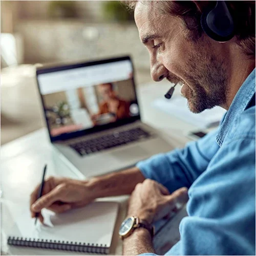 Lavoratore che segue un corso online e prende appunti